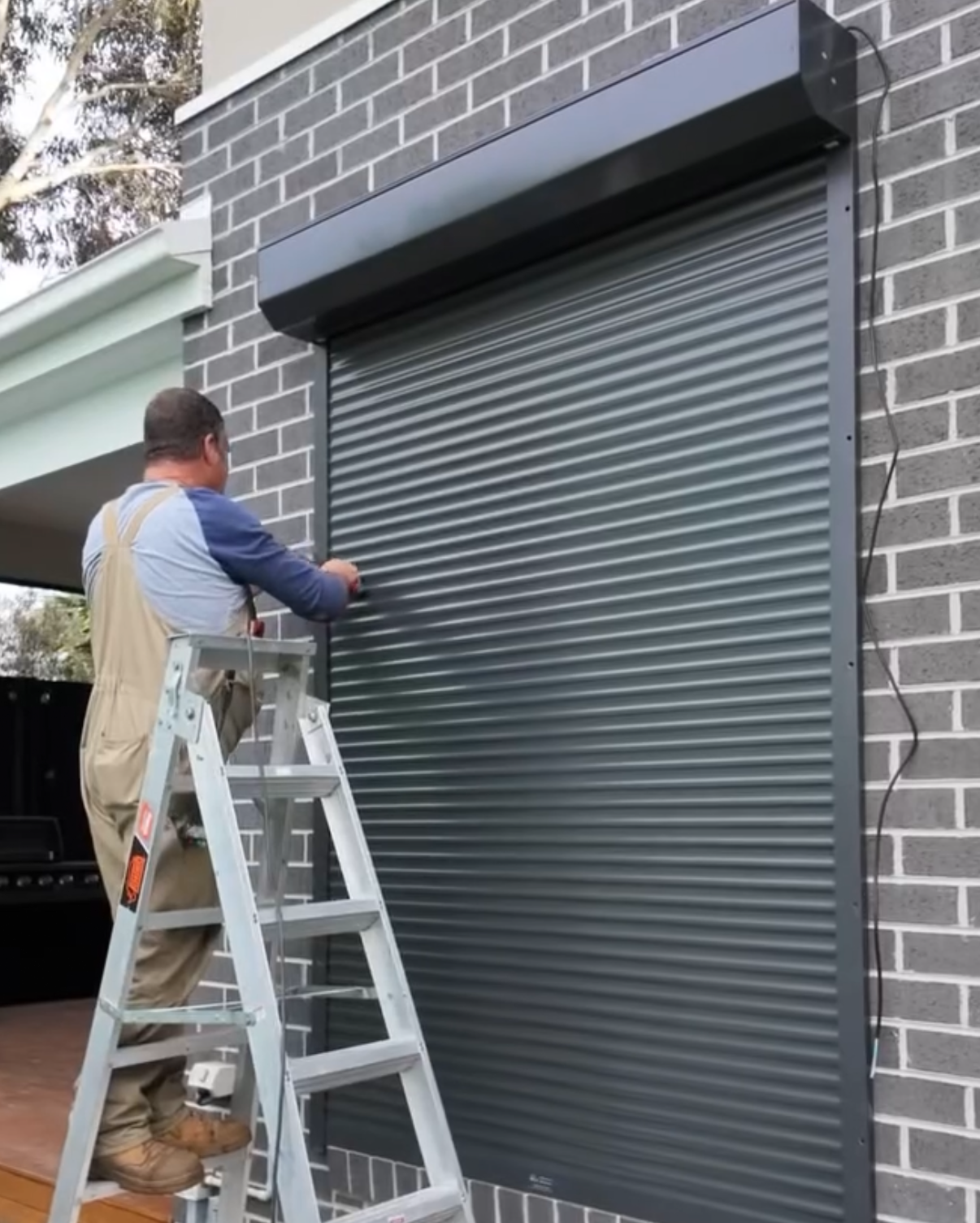Chris on ladder installing shutters