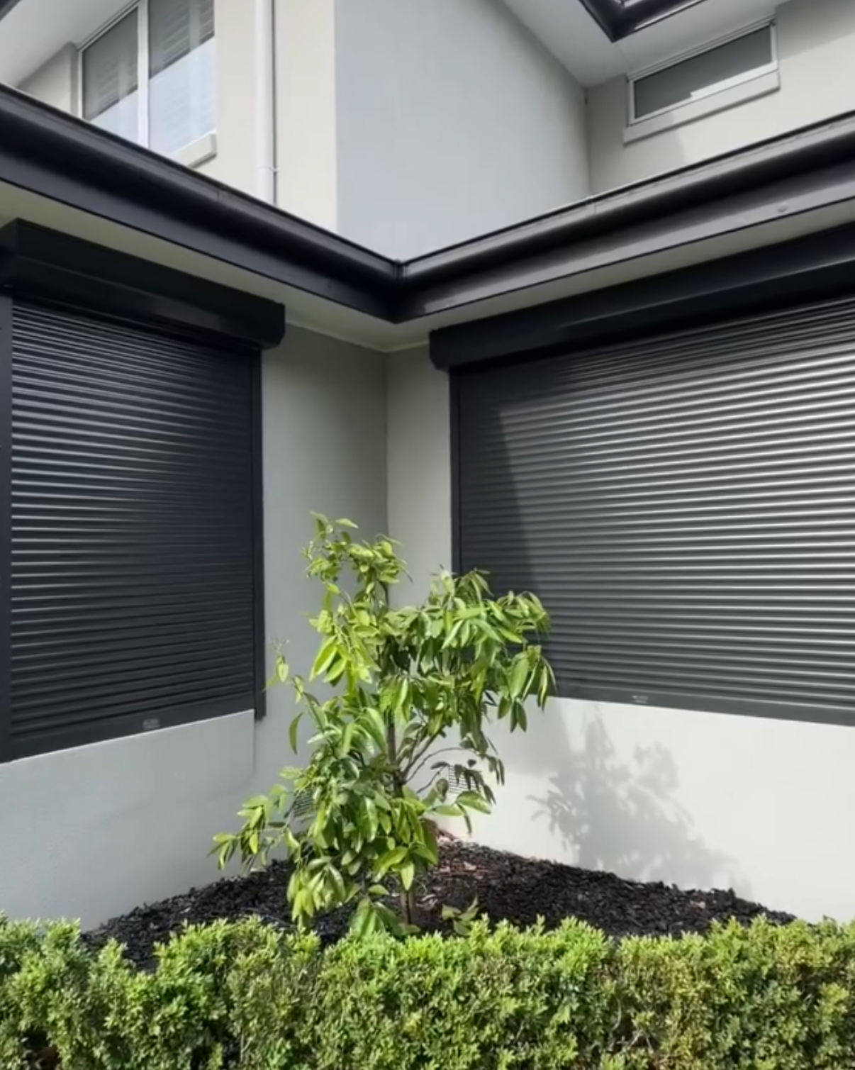 Completed roller shutters on a modern corner home